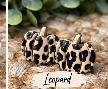 Colorful pumpkin stud earrings in orange, pink, green, blue, white, black, leopard print, and other fall colors displayed together.